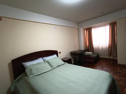 波托西Apartamento cómodo的一间卧室配有一张带绿色床单的床和一扇窗户。