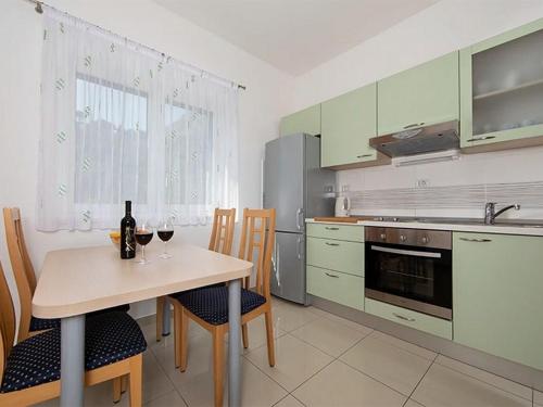 伊格拉恩Apartments by the sea Igrane, Makarska - 17292的厨房配有一张桌子和两杯葡萄酒