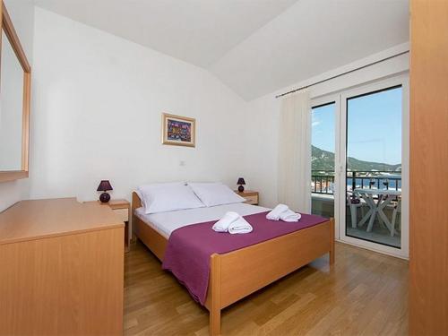 伊格拉恩Apartments by the sea Igrane, Makarska - 17292的一间卧室配有一张床,上面有两条毛巾