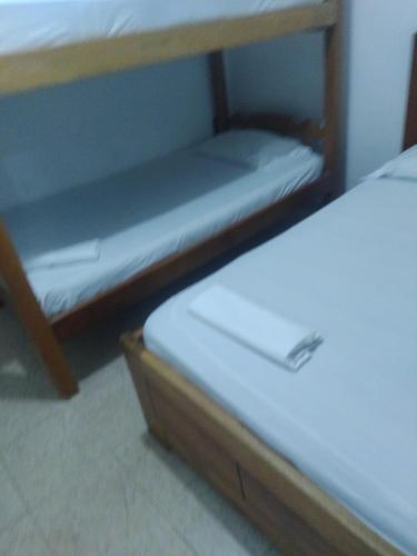 科韦尼亚斯Coveñas Mary plaza的宿舍间的两张双层床位 - 带白色床单