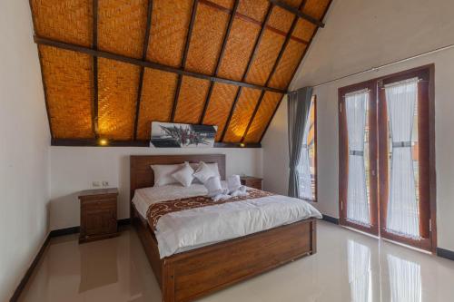 珀尼达岛Maskot Penida Cottage的一间卧室设有一张床和一个大窗户