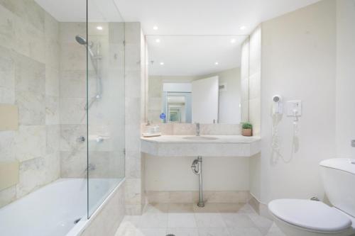 黄金海岸Ocean View Studio with Rooftop Jacuzzi的带淋浴、盥洗盆和卫生间的浴室