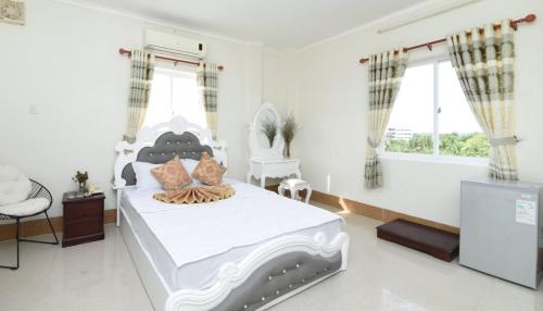 Mỹ AnKhách sạn Đồng Tháp - Hoàng Gia Minh Lợi的卧室配有白色的床和电视。