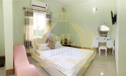 Mỹ AnKhách sạn Đồng Tháp - Hoàng Gia Minh Lợi的一间卧室配有一张大床和一张粉红色的椅子