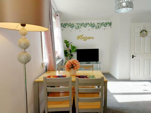 拉格斯The Blossom - Largs的一间带桌椅和电视的用餐室