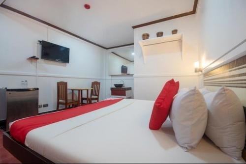 Lapu Lapu CityMax Travellers Inn的卧室配有带红色枕头的大型白色床