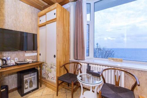 青岛青岛美墅假期酒店（五四广场万象城店）的客房设有桌椅和大窗户。