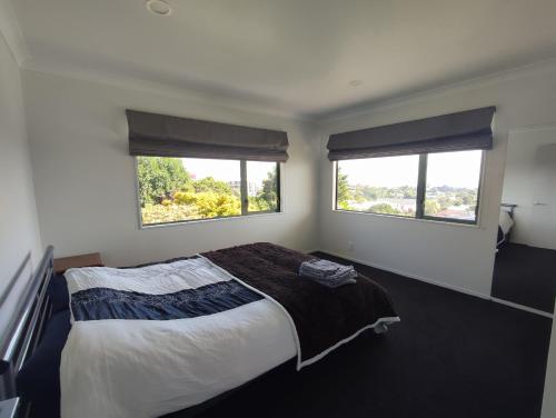 新普利茅斯Panoramic vista on burns的一间卧室设有一张大床和两个窗户