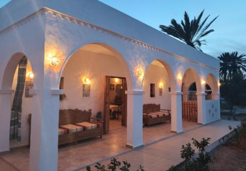 米多恩Djerba rêve vacances Zohra的白色的建筑,在庭院里配有沙发