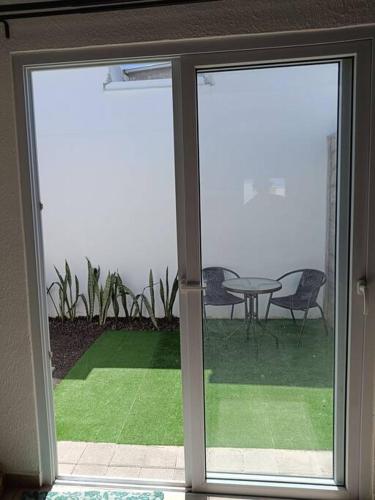 圣安娜Mini casa Ecoterra Santa Ana的滑动玻璃门,带桌椅的庭院
