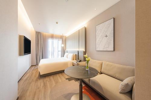 上海上海陆家嘴世博中心亚朵S酒店的酒店客房设有一张沙发和一张床