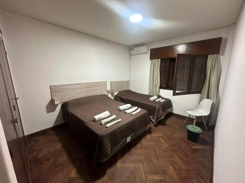 萨尔塔Hostal Vicente的一间设有两张床和椅子的房间
