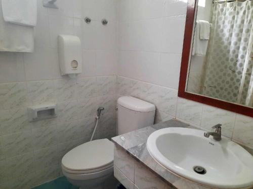 武里南Siam Boutique Hotel โรงแรมสยามบูทีค的白色的浴室设有卫生间和水槽。