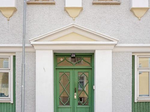 斯特伦斯塔德6 person holiday home in STR MSTAD的建筑上一扇带窗户的绿色门