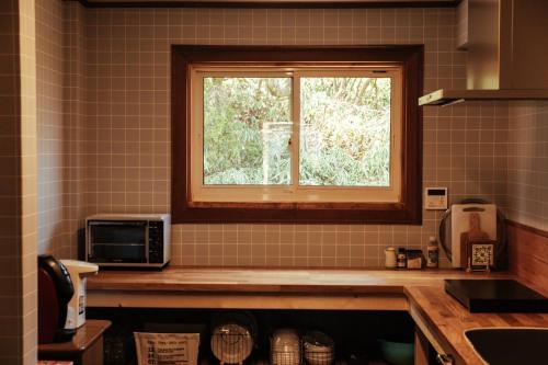 神户Renesto aHOLIDAYHOME - Vacation STAY 27984v的厨房的角落设有一个窗口