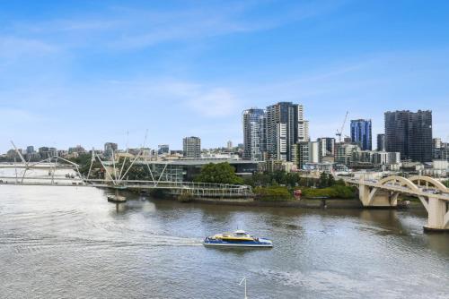 布里斯班Central Brisbane Studio with Stunning River Views的河中船,城市背景