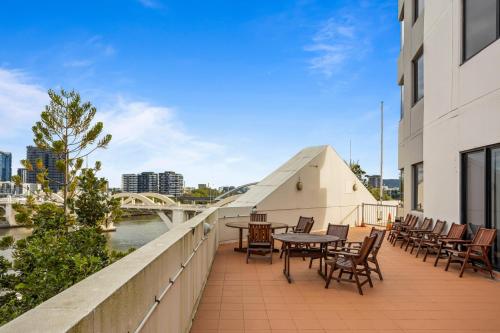 布里斯班Central Brisbane Studio with Stunning River Views的大楼内带桌椅的阳台