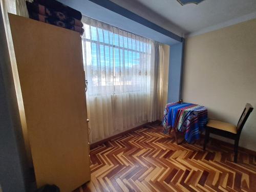 普诺Departamento Las Malvinas Puno的一间设有门、椅子和窗户的房间