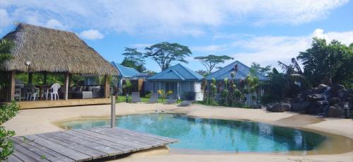 AfaahitiVai Iti Lodge的一个带游泳池和小屋的度假村