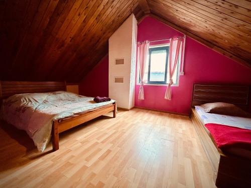卡夫尔高原La Kaz du Volcan-Capacité maximum 10 personnes的一间卧室设有粉红色的墙壁和木地板