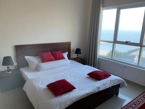阿吉曼Family rooms with beach view يستضيف مكان الإقامة هذا العائلات فقط的一间卧室设有两张床和大窗户