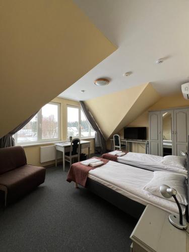 比尔扎伊Butenas Hotel Tyla的一间卧室配有一张大床和一张书桌