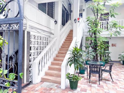 马尼拉SANTOS Pension House的一个带桌椅和植物的楼梯
