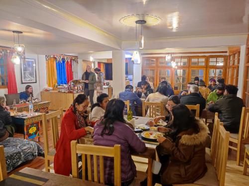 列城Snow Lion Ladakh的一群坐在餐厅桌子上的人