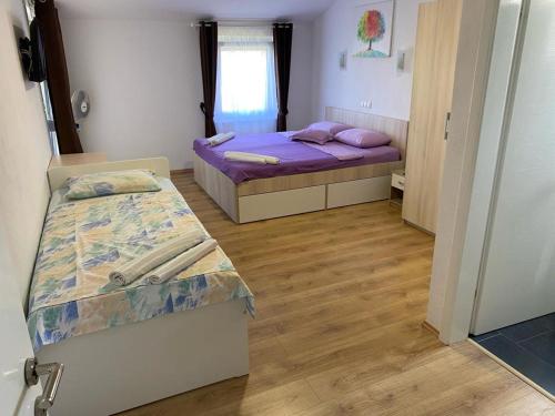 沃希Apartmani FILTEA的紫色床单的客房内的两张床