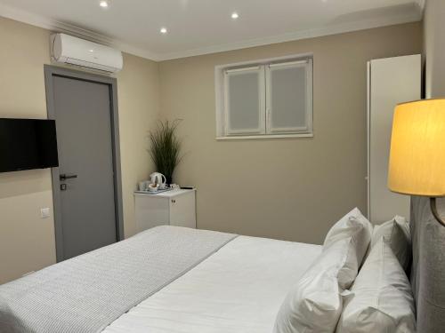索瓦塔Vila Niki的卧室配有一张大白色床和窗户