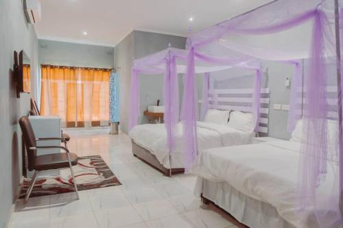 MangochiAdams lodges Ltd的紫色卧室配有两张床和一把椅子