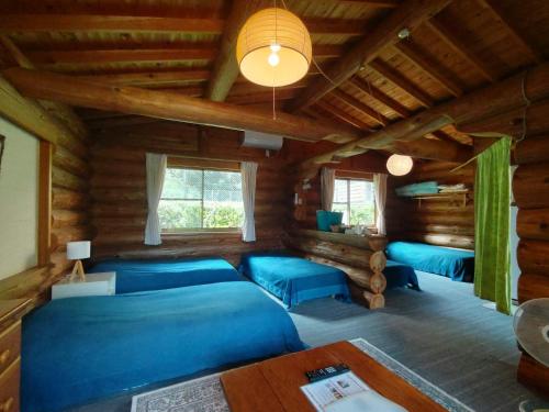 ShishikuiPension Shishikui的小木屋内的一个房间,配有蓝色的床