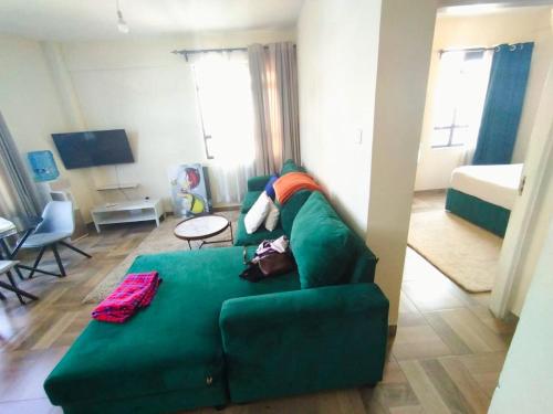 纳库鲁pgs plaz的客厅配有绿色沙发和床。