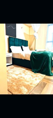 纳库鲁pgs plaz的一间卧室配有一张带绿床单和地毯的床。