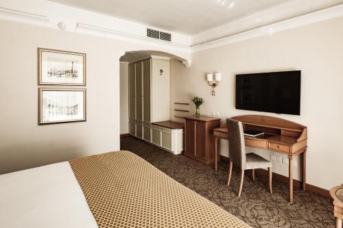 阿塔德Corinthia Palace Malta的酒店客房配有书桌和电视。