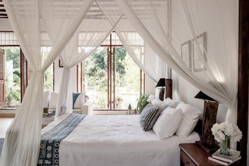 基利菲Tarangau Retreat的一间卧室配有一张带天蓬的白色床