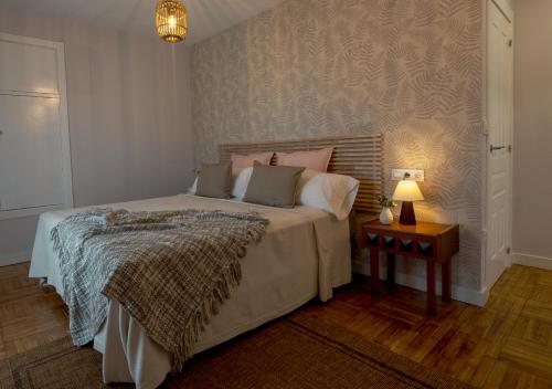 卢安科Casa Manolo的一间卧室配有一张床和一张带台灯的桌子