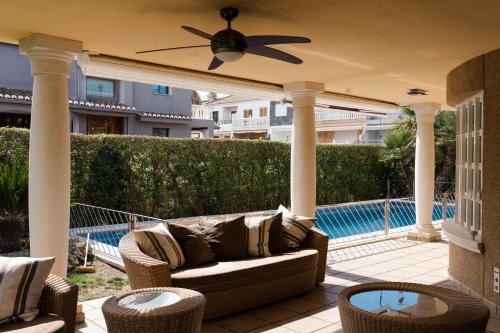 瓦伦西亚Experience Valencia Luxury Chalet Puig Val con piscina的一个带沙发和椅子的庭院,毗邻一个游泳池