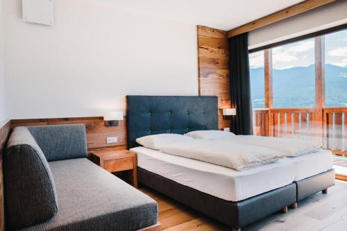 韦尔图尔诺沃玛伍尔酒店的一间卧室配有一张床、一张沙发和一个窗口