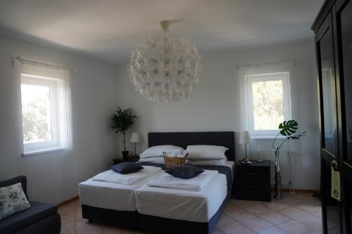 伊穆尼Villa Olea的一间卧室配有两张床和吊灯。