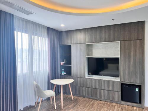富国Le Anh Hotel的客厅配有桌子和电视