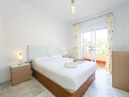 马贝拉Cubo's Cabopino Beach Marbella Apartment的一间卧室设有一张大床和一个大窗户
