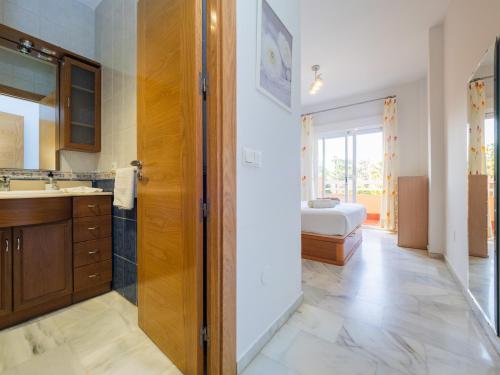 马贝拉Cubo's Cabopino Beach Marbella Apartment的一间带水槽的浴室和一张位于客房内的床