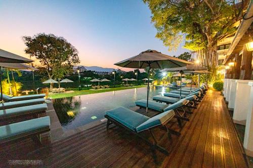 清迈Buri Sriping Riverside Resort & Spa - SHA Extra Plus的游泳池旁的一排躺椅