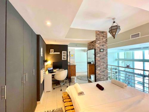 迪拜Urban Oasis Duplex Loft Wabundant Natural Light的一间卧室配有一张床和一张书桌