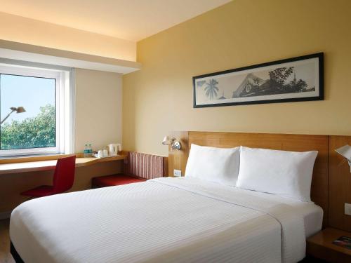 浦那ibis Pune Viman Nagar - An Accor Brand的酒店客房设有床和窗户。