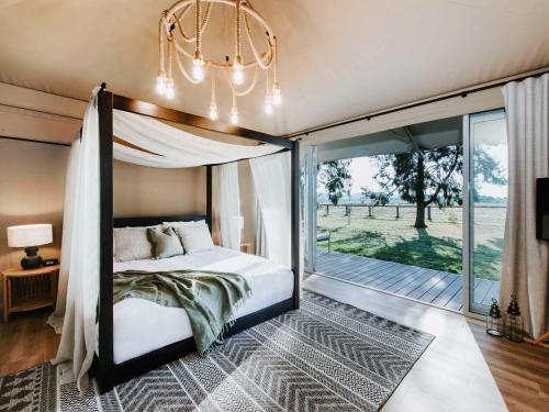 马奇Parklands Resort的一间卧室设有一张天蓬床和一个阳台