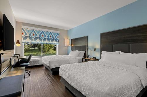 克里斯琴斯堡Tru By Hilton Christiansburg的酒店客房设有两张床和窗户。