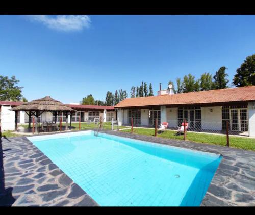 卢汉德库约POSADA DE LA LUNA的一座大蓝色游泳池,位于房子前