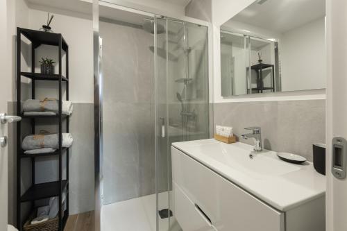 米兰Moderno e Confortevole Loft tra Navigli e Bocconi的一间带水槽和玻璃淋浴的浴室